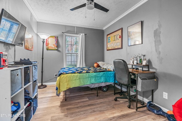 bedroom featuring ceiling fan, light wood-type flooring, a textured ceiling, and ornamental molding