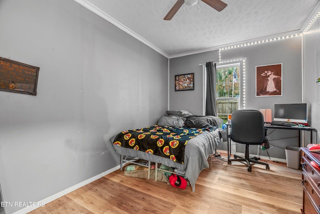 bedroom featuring ceiling fan, light hardwood / wood-style flooring, a textured ceiling, and ornamental molding