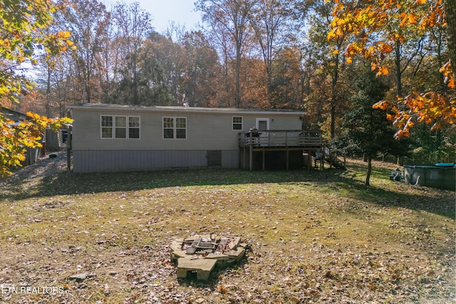 back of property with a lawn and a deck