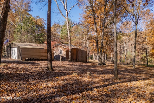 view of yard with a garage and an outbuilding