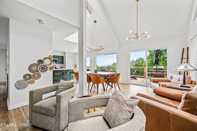 living room with beam ceiling, light hardwood / wood-style flooring, high vaulted ceiling, and a notable chandelier