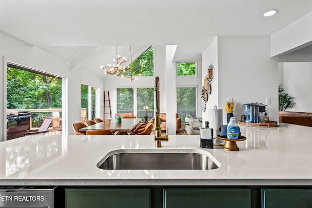 kitchen with pendant lighting, vaulted ceiling with beams, sink, and a chandelier