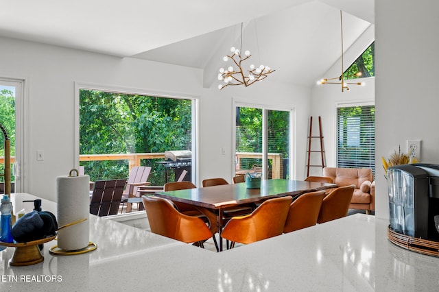 dining area with a wealth of natural light, vaulted ceiling, and a notable chandelier