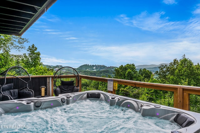 wooden terrace featuring a mountain view and a hot tub