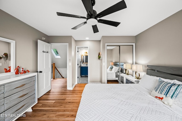 bedroom with light wood-type flooring, a closet, ceiling fan, and connected bathroom