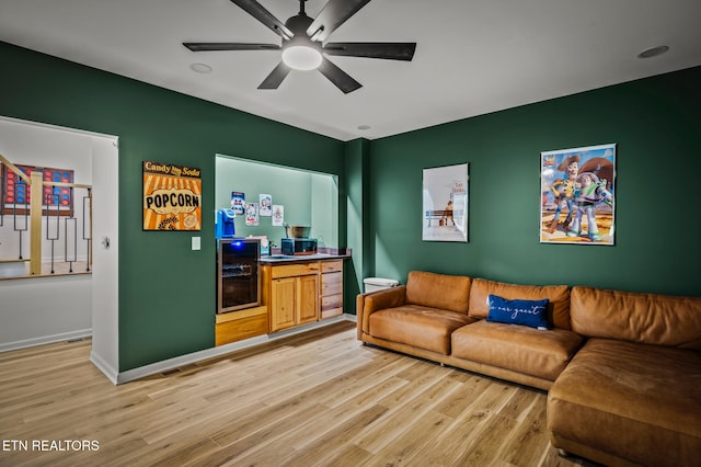 living room featuring ceiling fan, beverage cooler, and light wood-type flooring