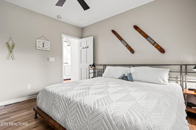 bedroom with washer / dryer, ceiling fan, and hardwood / wood-style flooring