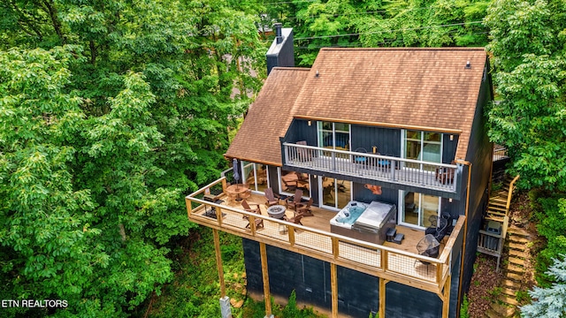 rear view of property featuring a hot tub