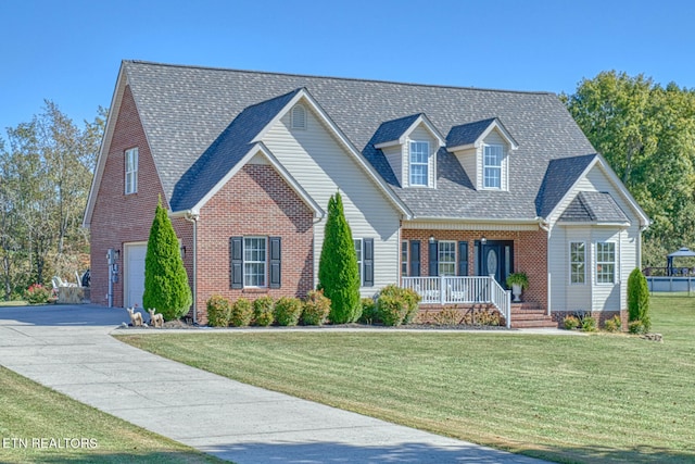 cape cod-style house featuring covered porch, a front yard, and a garage