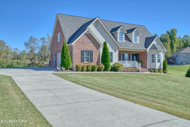 view of front of property featuring a porch, a garage, and a front lawn