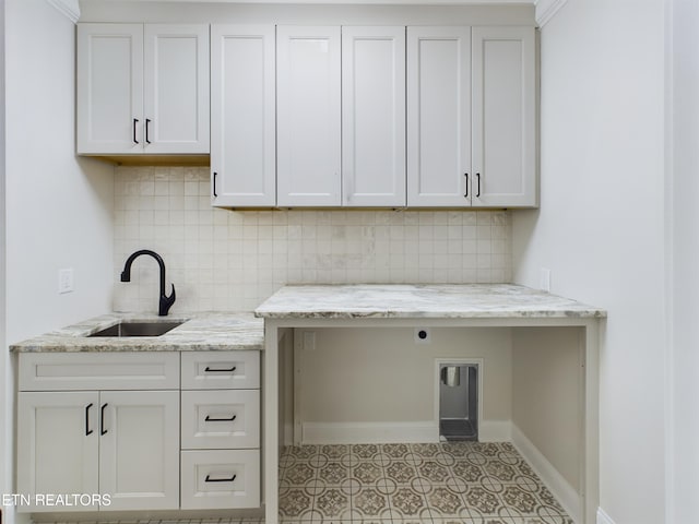 laundry room featuring electric dryer hookup, a sink, cabinet space, and baseboards