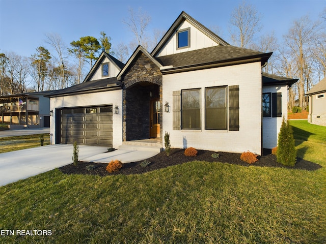 view of front of home featuring an attached garage, brick siding, driveway, a front lawn, and board and batten siding