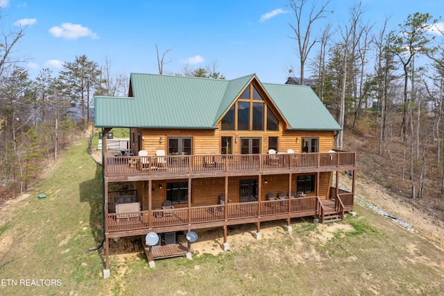 back of property with a lawn and a deck