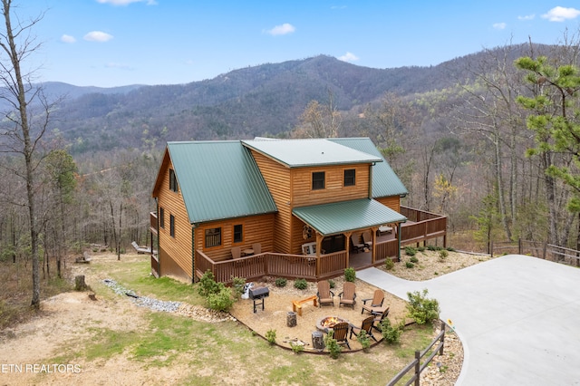 view of front of home with a mountain view and an outdoor fire pit