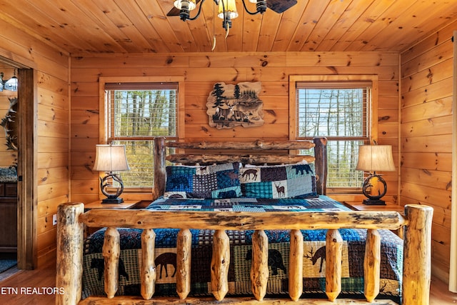 bedroom featuring wooden ceiling, wooden walls, and multiple windows