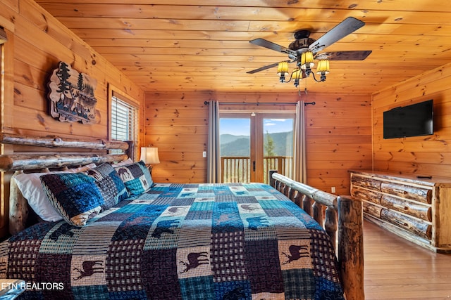 bedroom featuring access to exterior, light hardwood / wood-style floors, multiple windows, and ceiling fan