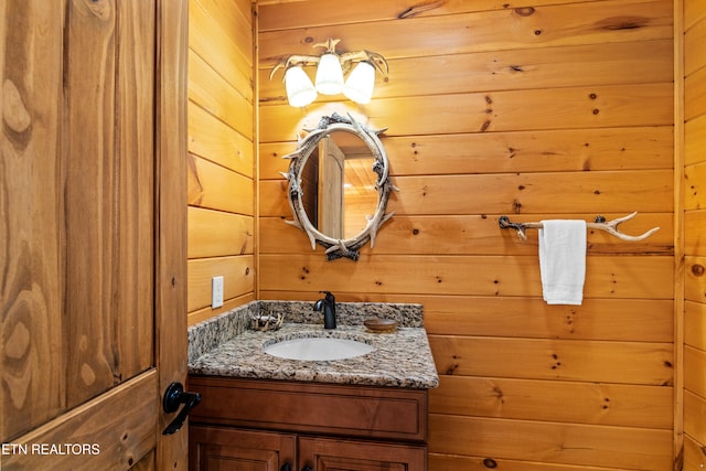 bathroom with vanity and wooden walls