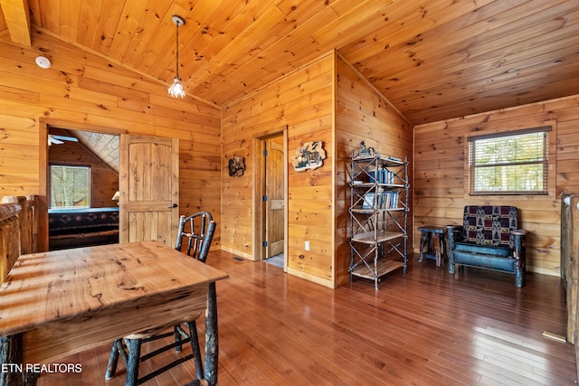 dining space featuring wood walls, hardwood / wood-style floors, wooden ceiling, and lofted ceiling