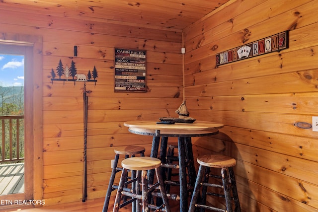 dining room with wooden ceiling and wood walls