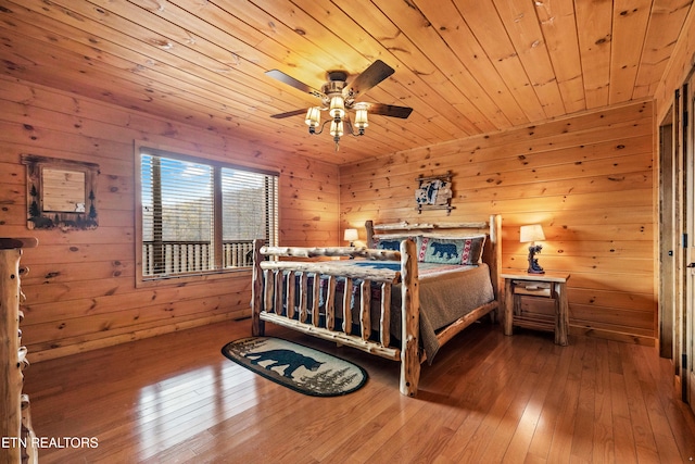 bedroom featuring wood walls, wood-type flooring, and wood ceiling