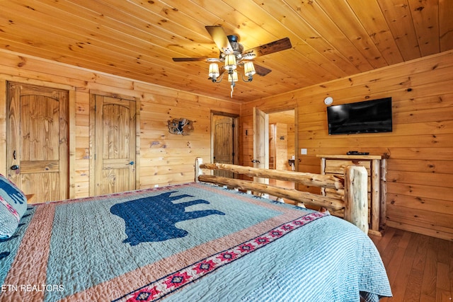 bedroom with ceiling fan, wooden walls, and wood-type flooring