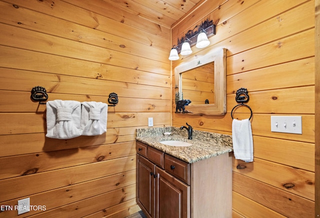 bathroom featuring wood walls, vanity, and wood ceiling