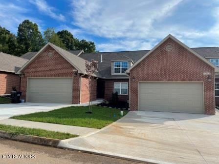 view of front of house with driveway, a garage, and brick siding