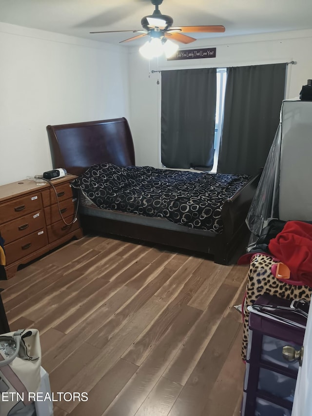 bedroom featuring hardwood / wood-style floors, ceiling fan, and crown molding