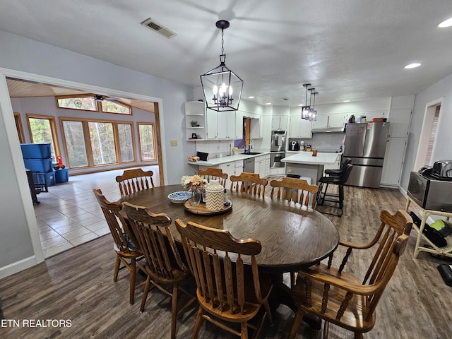 dining room with wood-type flooring, sink, and a chandelier