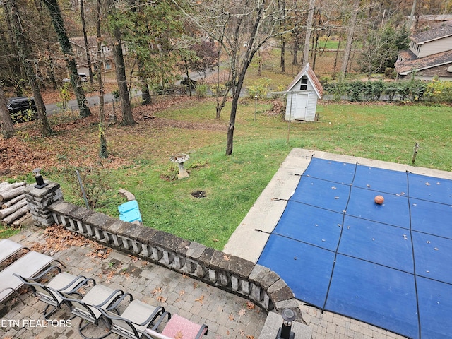 view of yard with a shed and a covered pool