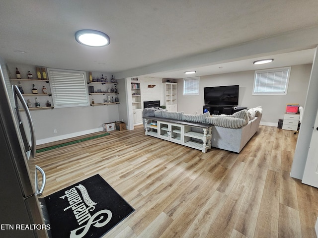 living room featuring a textured ceiling, light hardwood / wood-style floors, and a wealth of natural light