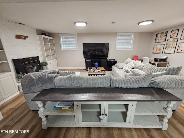 living room featuring a fireplace, hardwood / wood-style flooring, and a healthy amount of sunlight