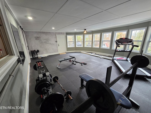 workout room with a paneled ceiling, plenty of natural light, and ceiling fan