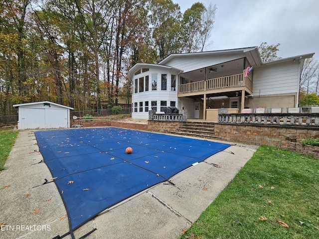 view of pool with a patio area, ceiling fan, a storage shed, and a sunroom