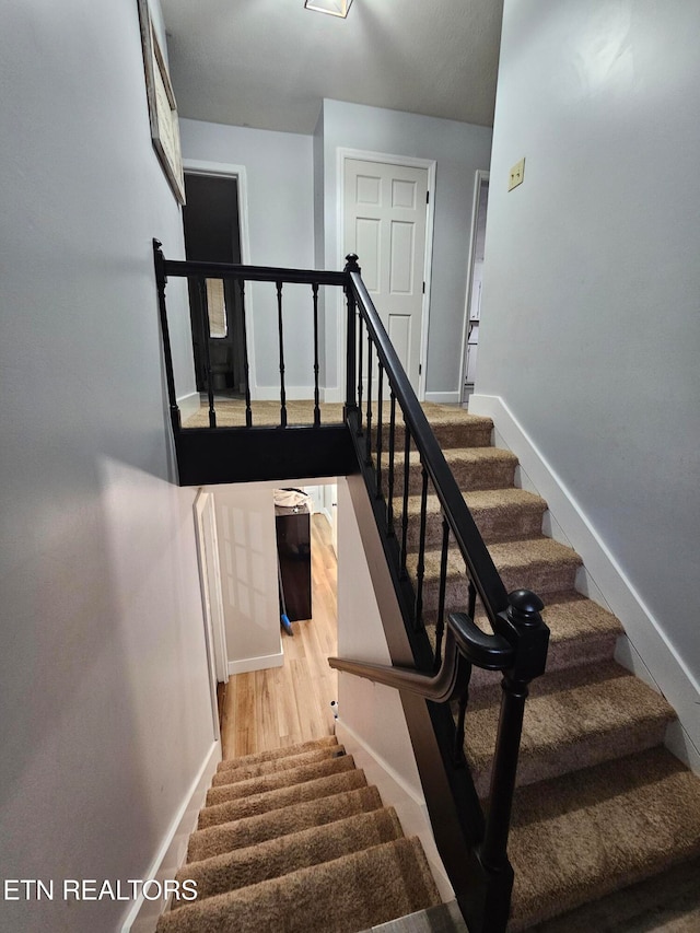 stairs featuring hardwood / wood-style flooring