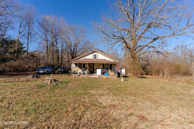 back of property with a yard and a porch