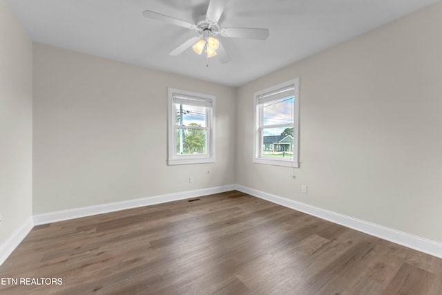 empty room featuring dark hardwood / wood-style flooring and ceiling fan