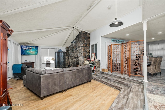 living room with hardwood / wood-style flooring, lofted ceiling, and a textured ceiling