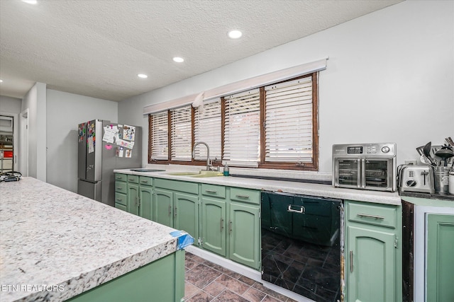 kitchen with dishwasher, a textured ceiling, stainless steel refrigerator, and green cabinetry