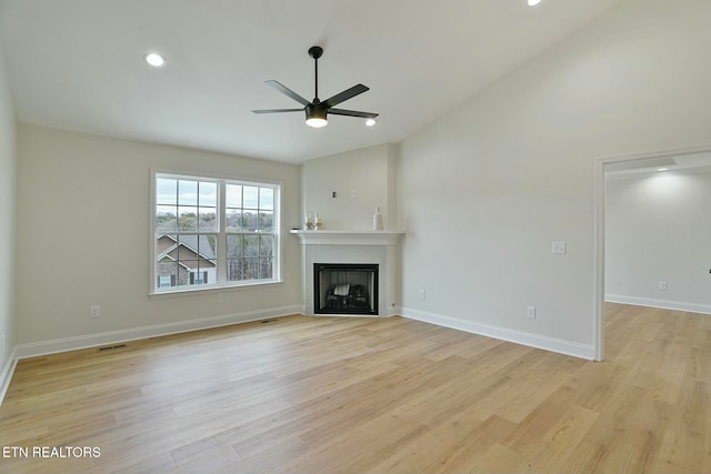 unfurnished living room with lofted ceiling, ceiling fan, and light hardwood / wood-style flooring