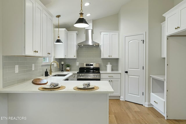 kitchen featuring sink, hanging light fixtures, white cabinets, stainless steel range with electric cooktop, and kitchen peninsula