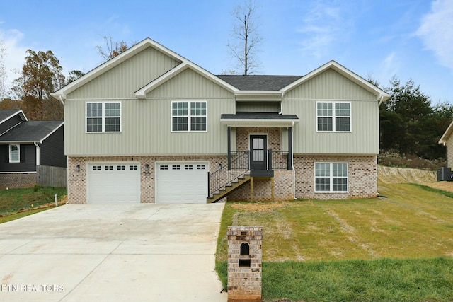 raised ranch featuring a garage and a front lawn