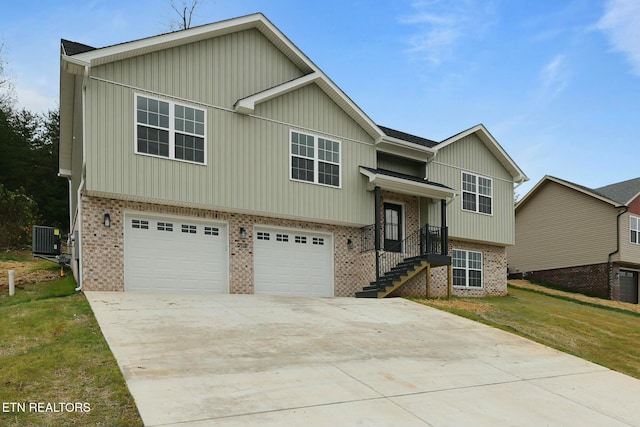 raised ranch featuring a garage, a front yard, and central AC unit