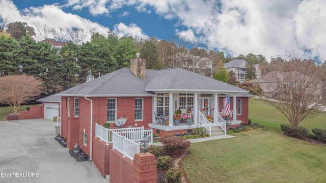 view of front facade featuring a porch, a garage, a front lawn, and an outdoor structure