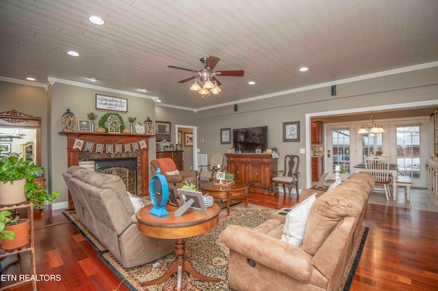 living room featuring crown molding, a fireplace, recessed lighting, wood finished floors, and ceiling fan with notable chandelier