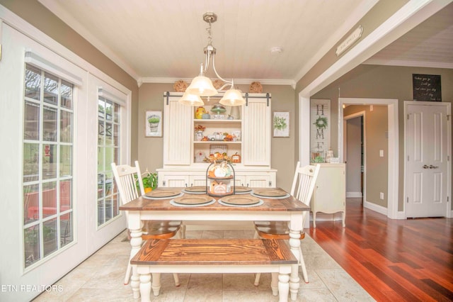 dining space featuring a chandelier, light wood-type flooring, and crown molding