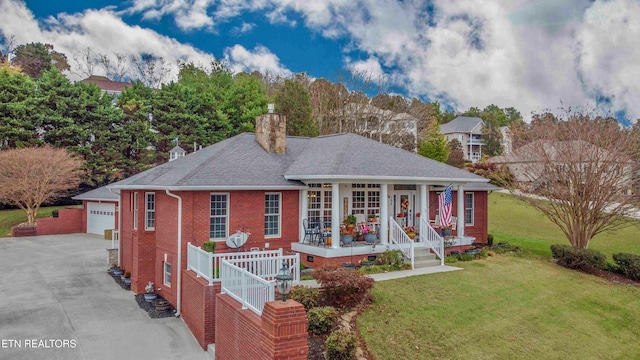 view of front of house with brick siding, a chimney, a porch, driveway, and a front lawn