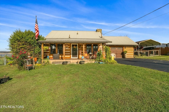 view of front of property with a carport, a garage, covered porch, and a front lawn