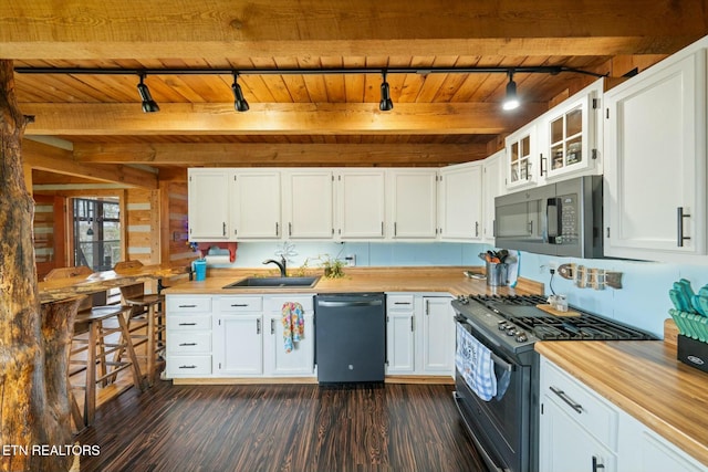 kitchen featuring dark hardwood / wood-style flooring, stainless steel appliances, sink, beam ceiling, and white cabinets