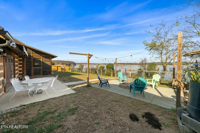 view of yard with a fire pit, a sunroom, a water view, and a patio